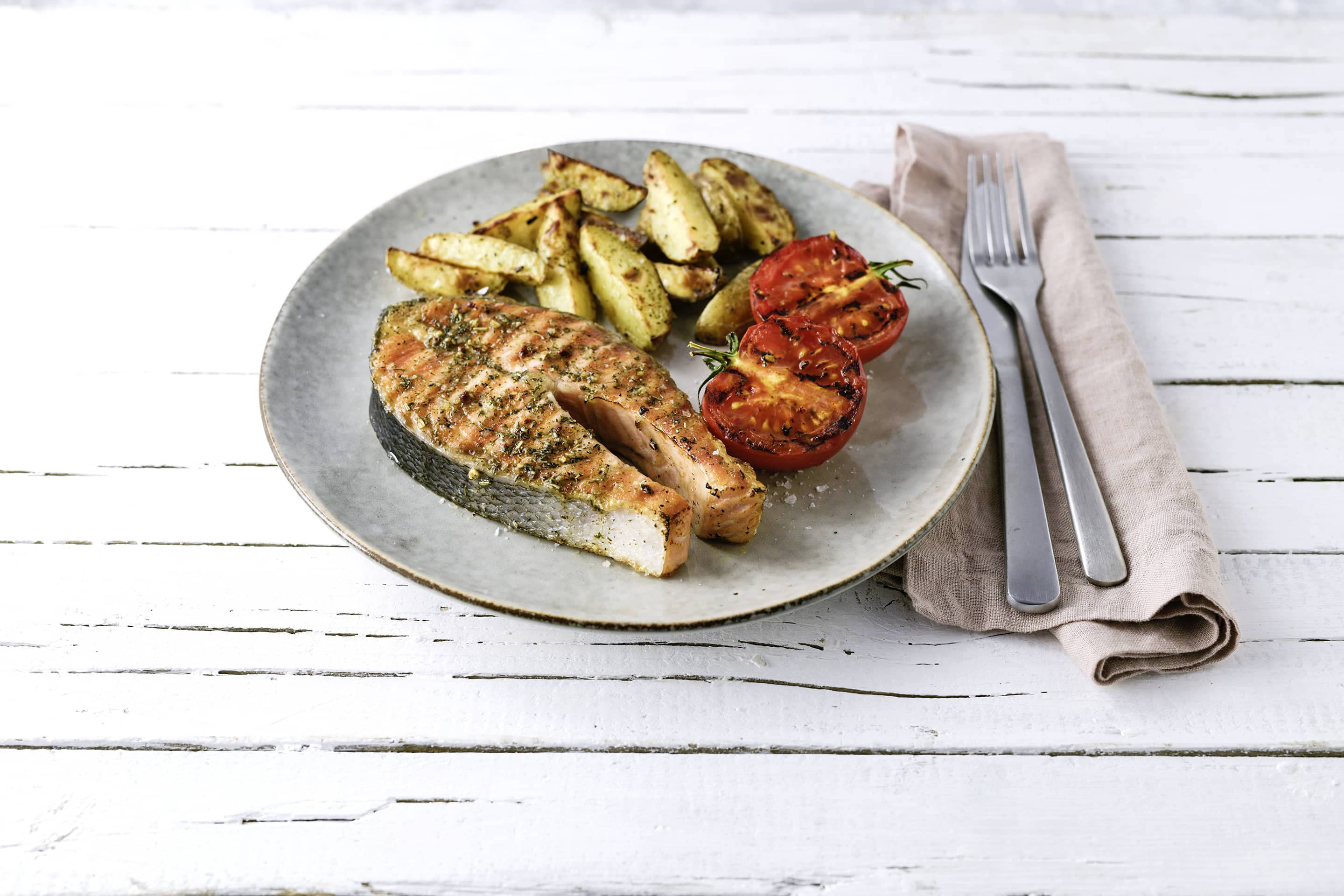 Lachssteak mit grill-fisch, grilltomaten und Kartoffel-wedges