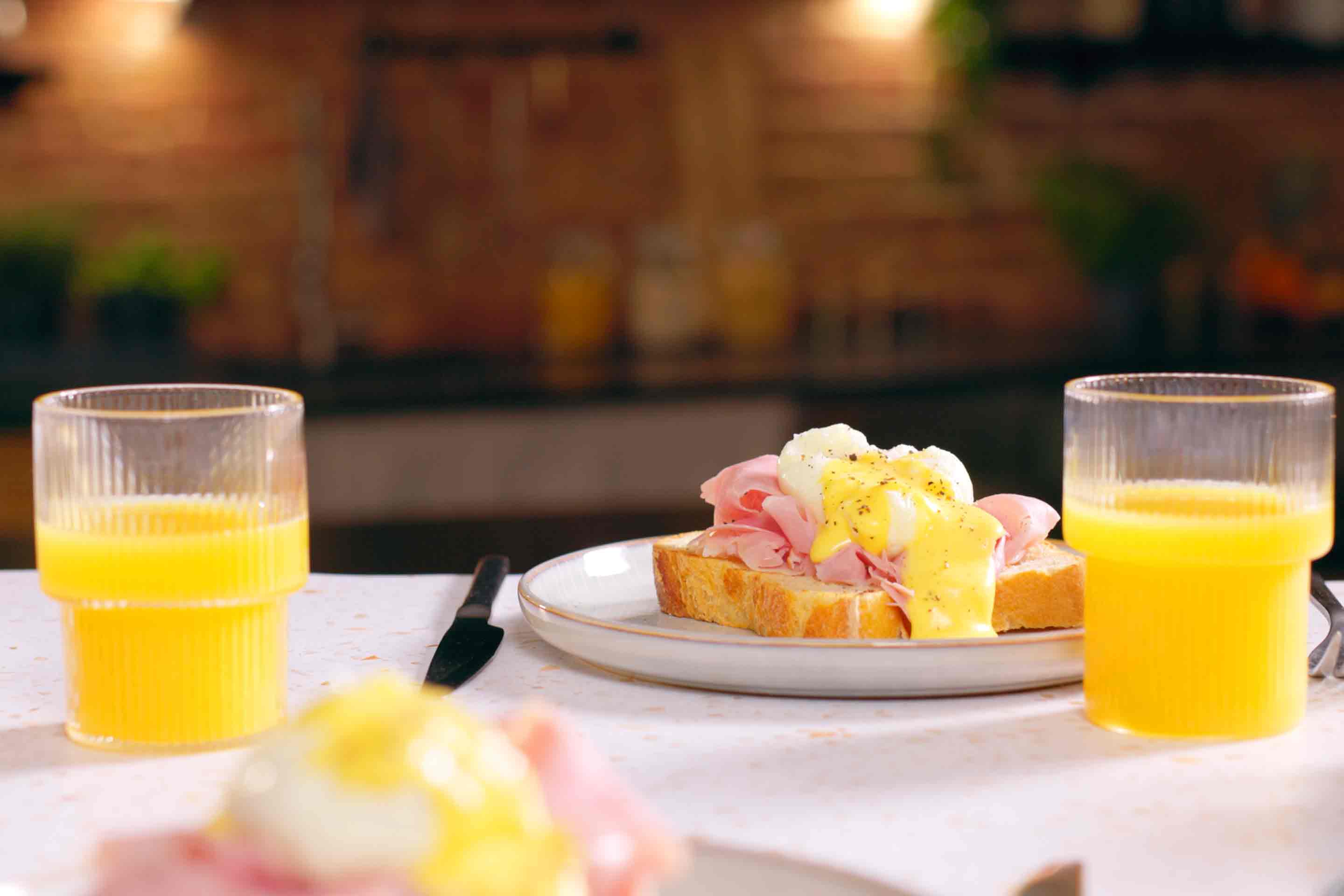 Френска класика: Яйца Бенедикт със сос Холандез, поднесени с портокалов сок за перфектната засищаща закуска