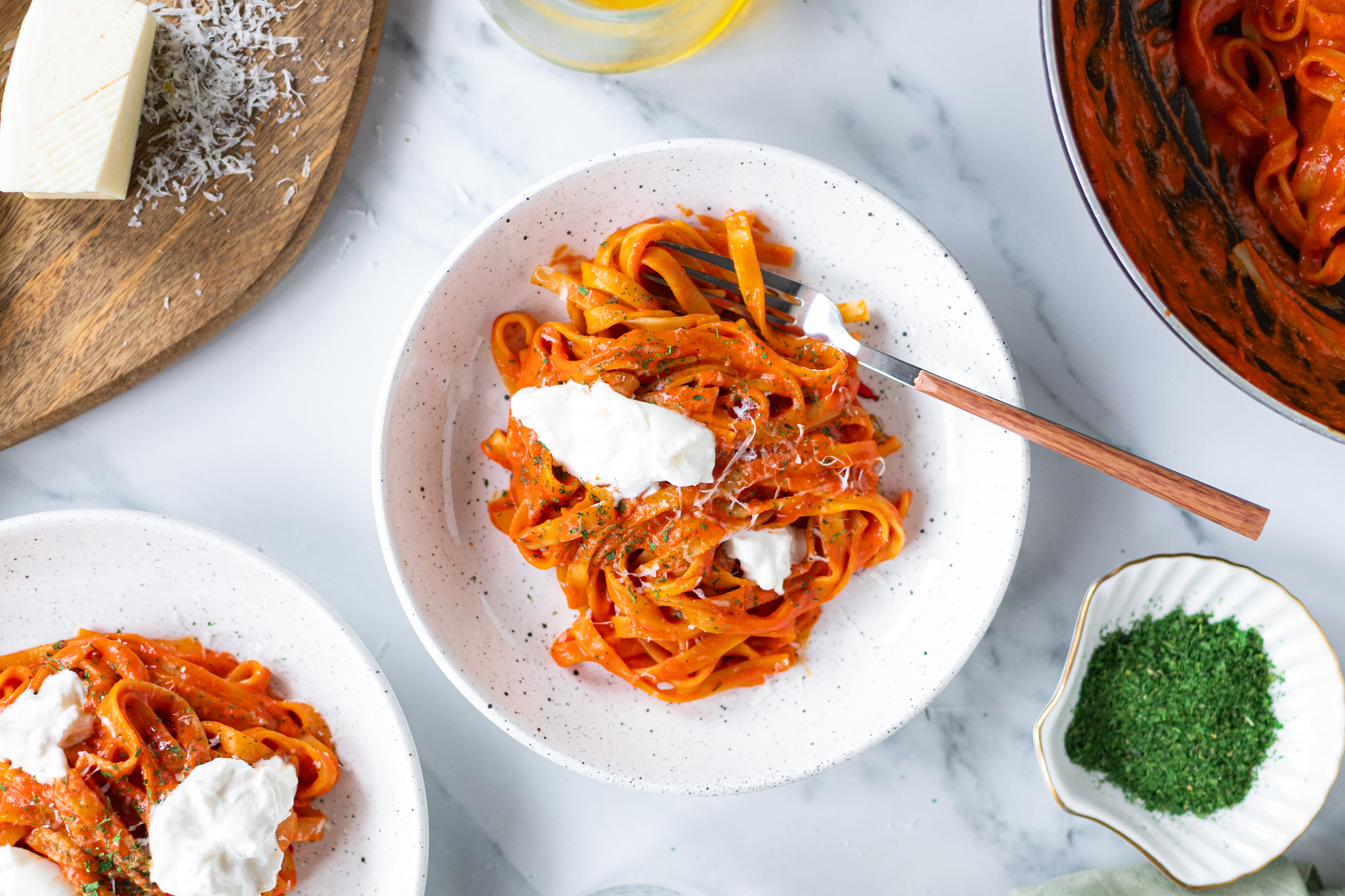 Порция талиателе в червен сос от печени чушки, с накъсано сирене бурата.